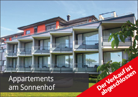 Modern apartment building with balconies and large windows, set in a green area. Text reads Appartements am Sonnenhof and a red banner says Der Verkauf ist abgeschlossen (The sale is complete).